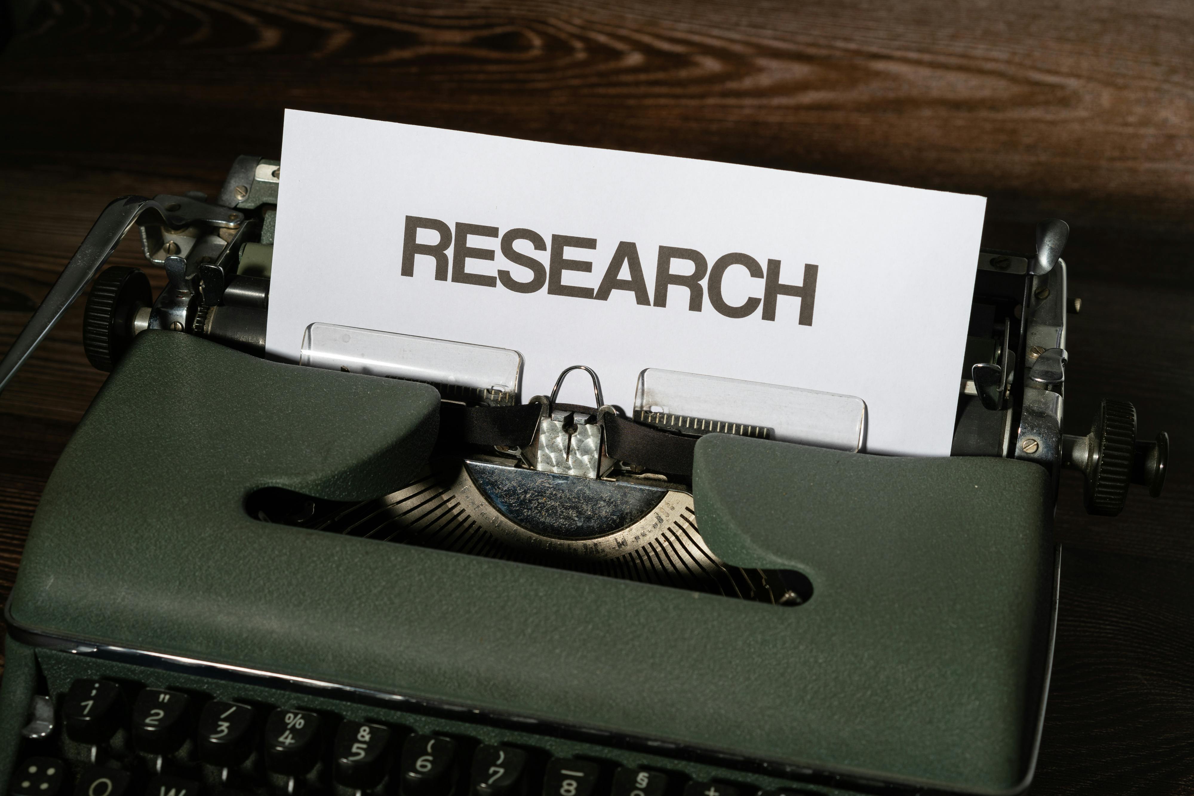 Picture of a type writer with a paper that sticks out saying 